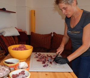 Angela schneidet Fleisch in der Küche für Katzenfutter